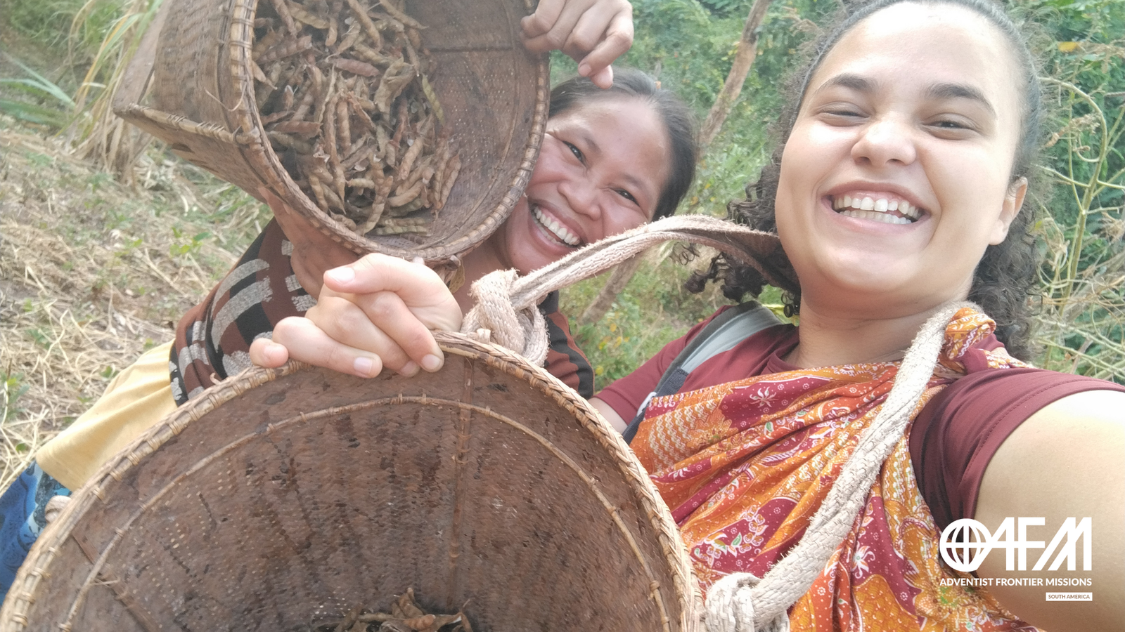 Missionária Brasileira com nativa palawana segurando cestos com a colheita e sorrindo