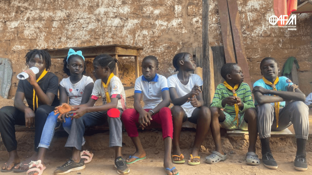 Desgosto e Esperança: Uma Mensagem de Conforto. Desbravadores sentados juntos em uma calçada.