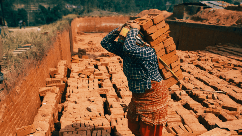 De amaldiçoado a abençoado - homem carregando tijolos nas costas com a ajuda de uma corda em uma construção.
